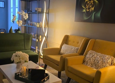 Effleurage Spa lounge with green sofa, yellow chairs, and floral decor in Charles Town, West Virginia, US.
