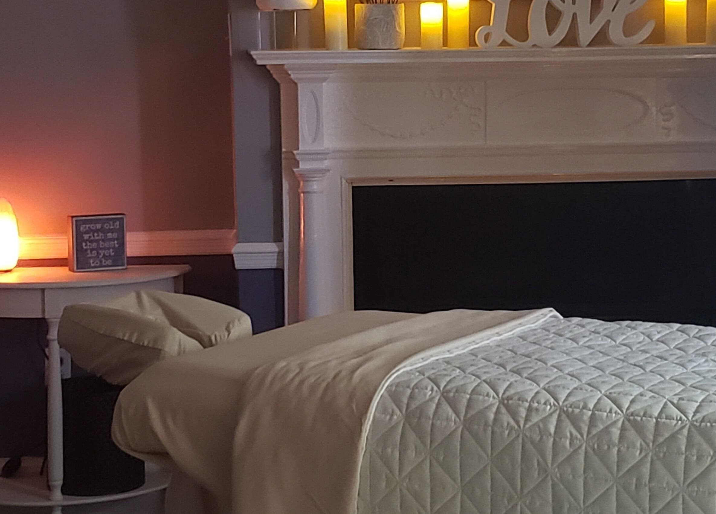 Relaxing massage room at Effleurage Spa, Charles Town, West Virginia, US with soft lighting and a cozy bed.
