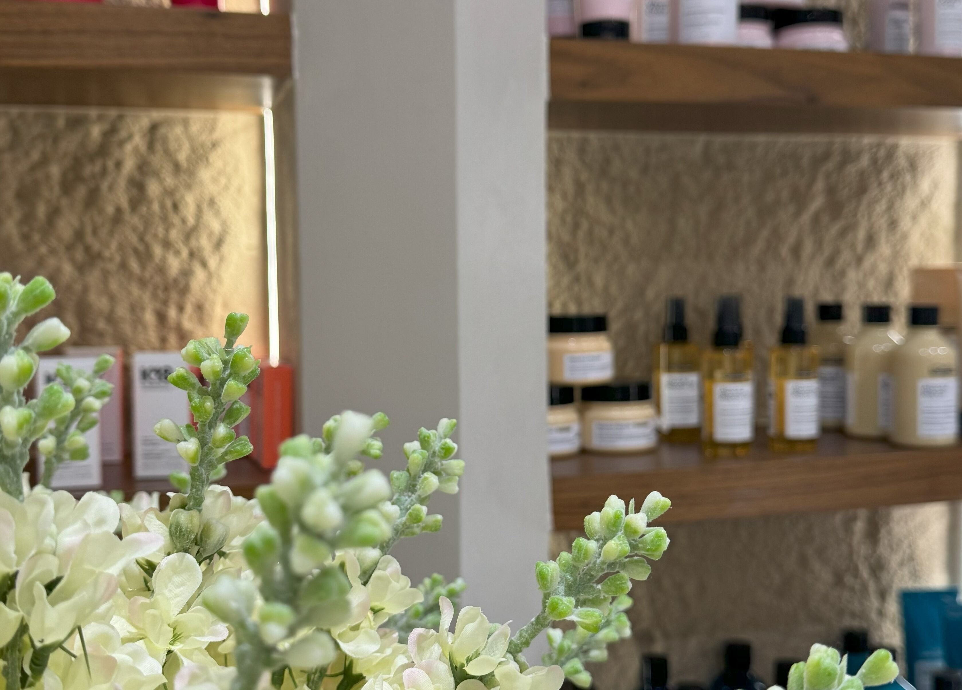 Luxurious beauty products on display at Haven Spa Khalifa Branch, Abu Dhabi, AE, with vibrant flower decor.