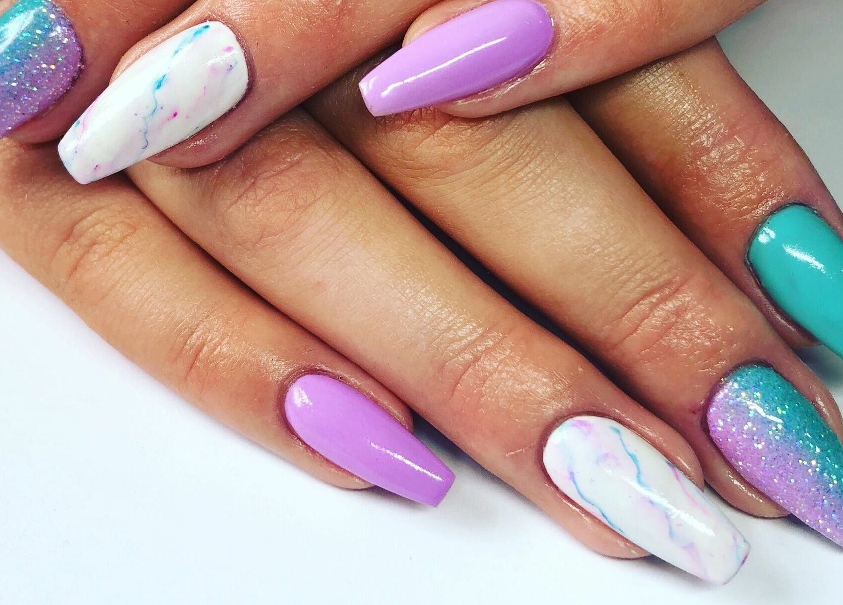 Colorful nail art manicure at Nail'd It, Todmorden, England, GB featuring vibrant designs and glossy finish.