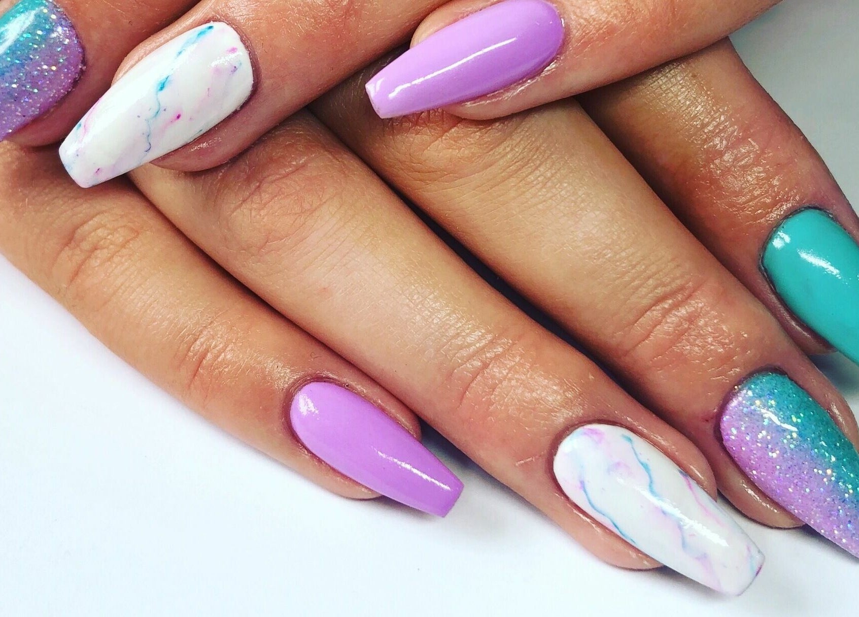 Colorful nail art manicure at Nail'd It, Todmorden, England, GB featuring vibrant designs and glossy finish.