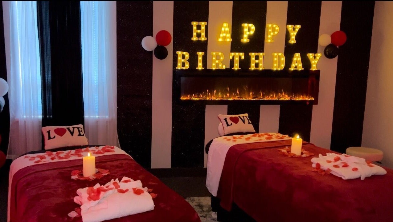 Romantic birthday setup at Elite Massage & Wellness Bloomfield, Connecticut, US with candles and rose petals.
