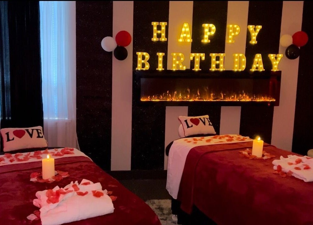Romantic birthday setup at Elite Massage & Wellness Bloomfield, Connecticut, US with candles and rose petals.