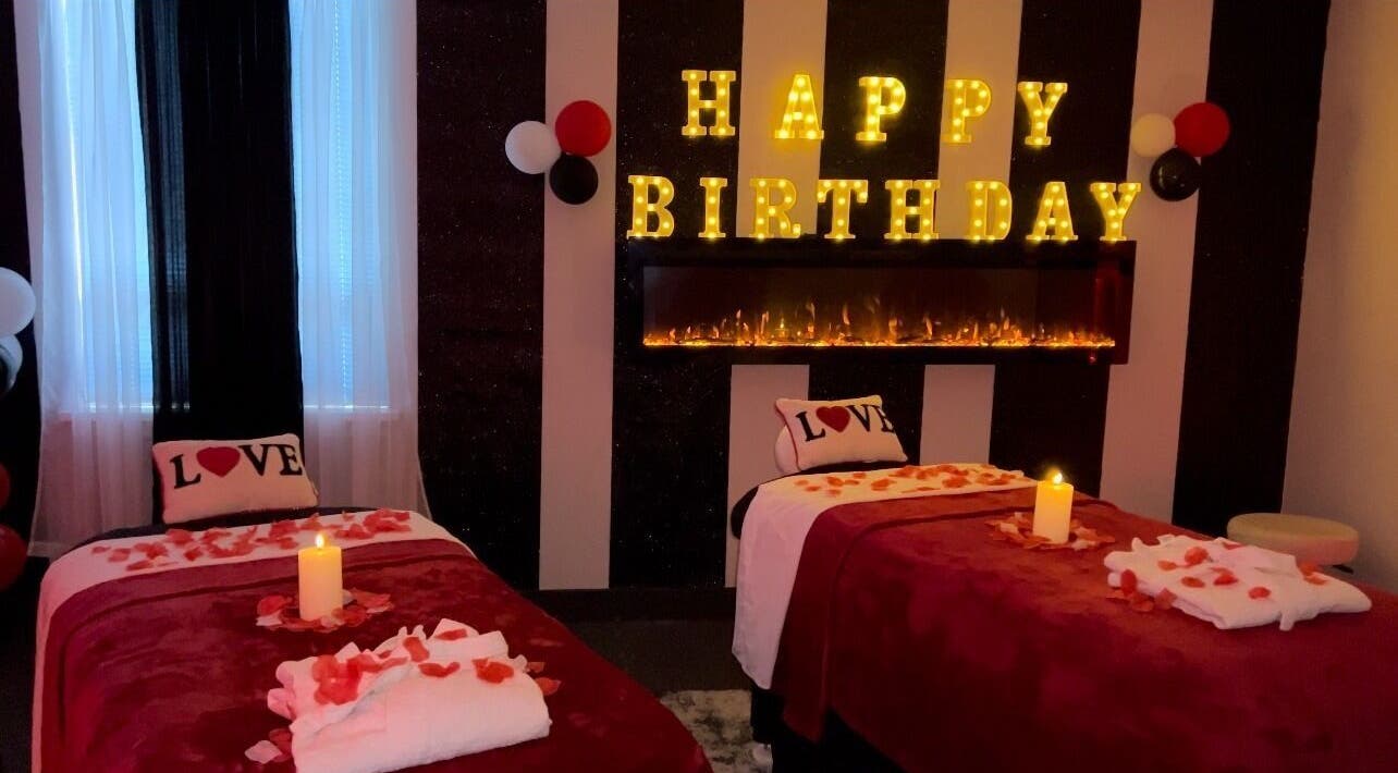 Romantic birthday setup at Elite Massage & Wellness Bloomfield, Connecticut, US with candles and rose petals.