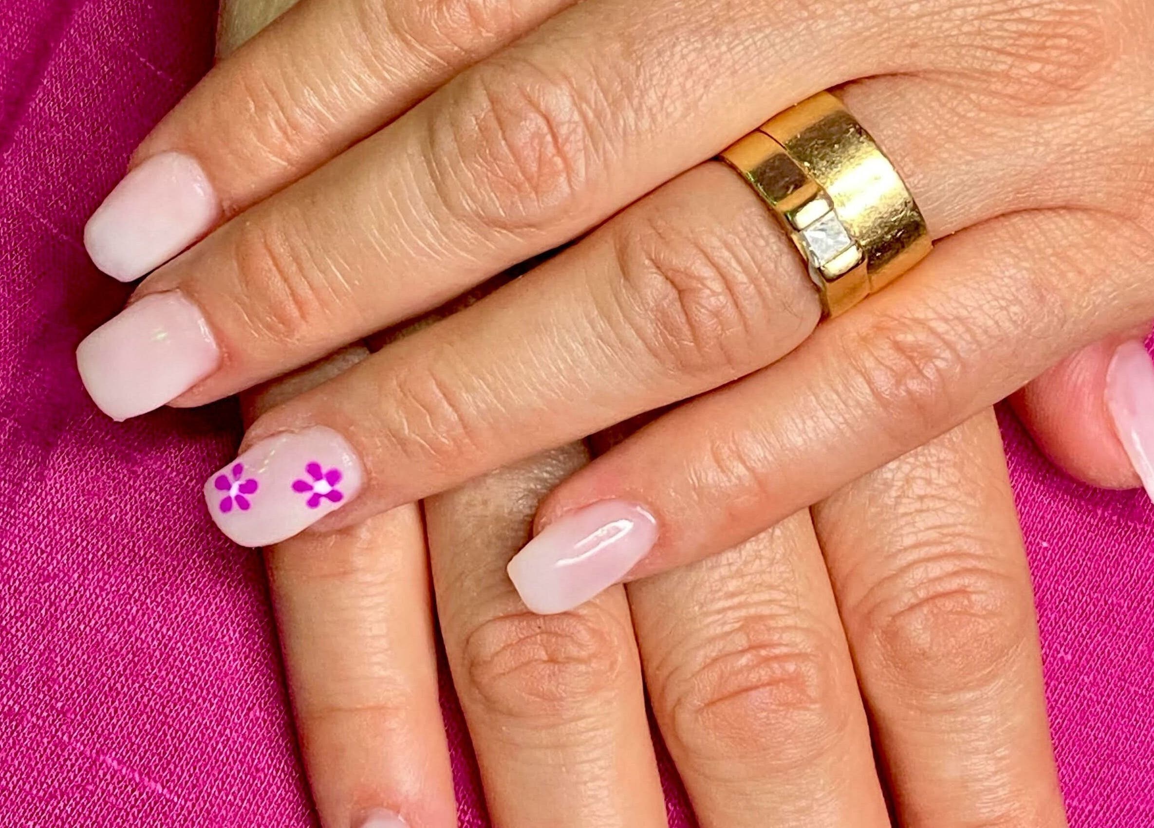 Elegant floral nail art at Exotic Touch in Barrie, Ontario, CA, featuring delicate pink and white designs.