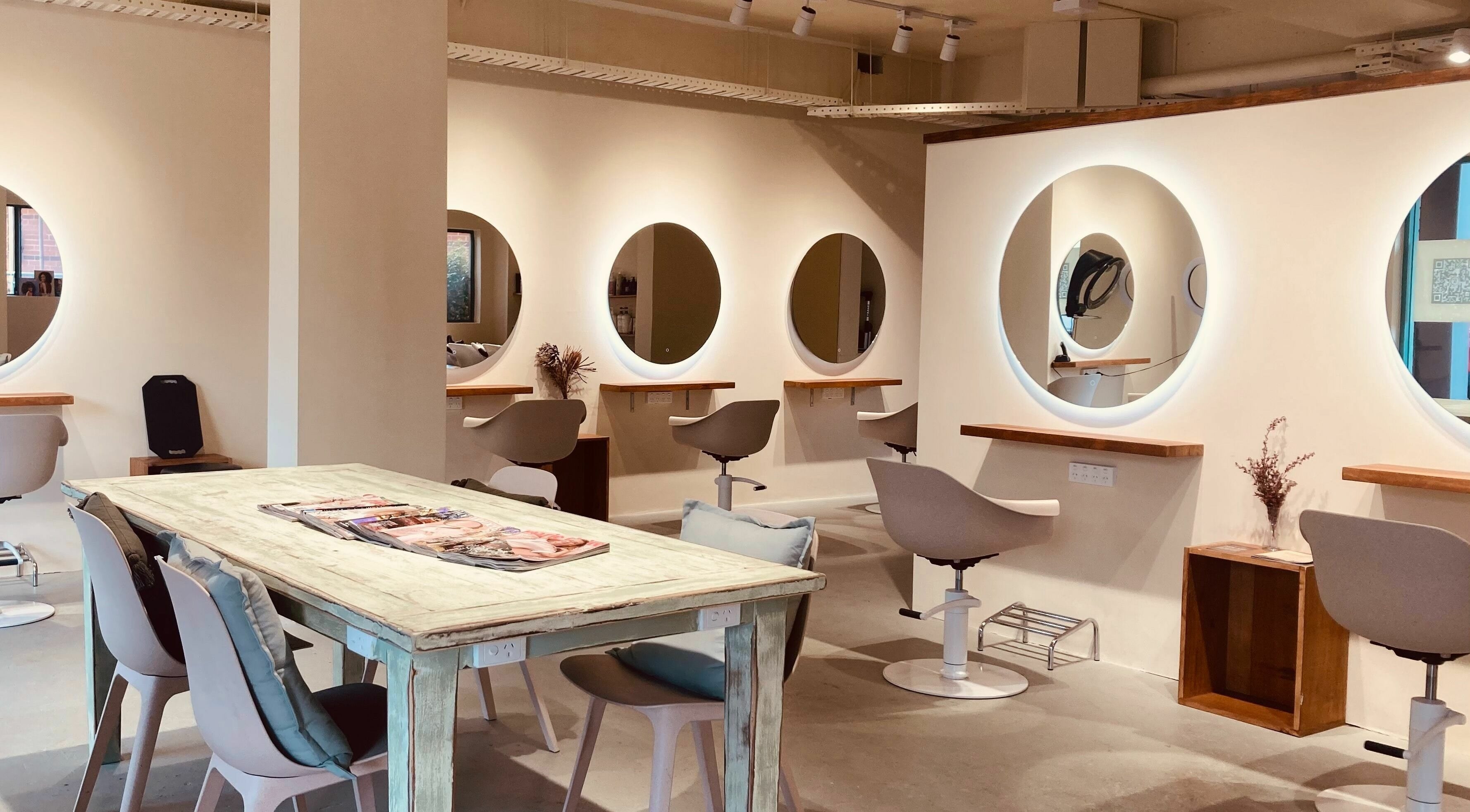 Spacious modern salon at Organic Hair Culture - Canterbury, New South Wales, AU with stylish mirrors and seating.