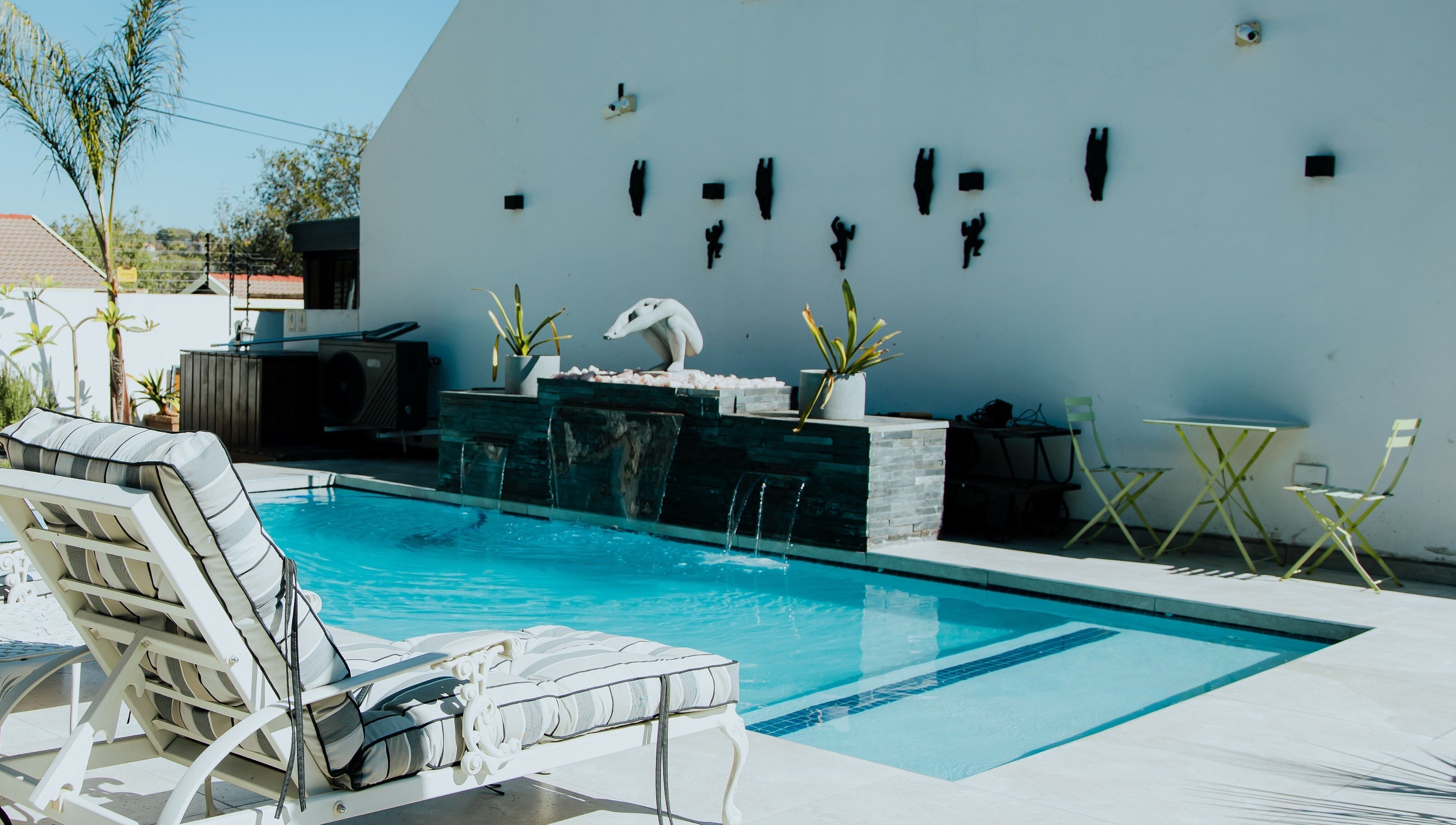 Relax by the pool at Thari Spa, Centurion, Gauteng, ZA, featuring elegant loungers and soothing water features.