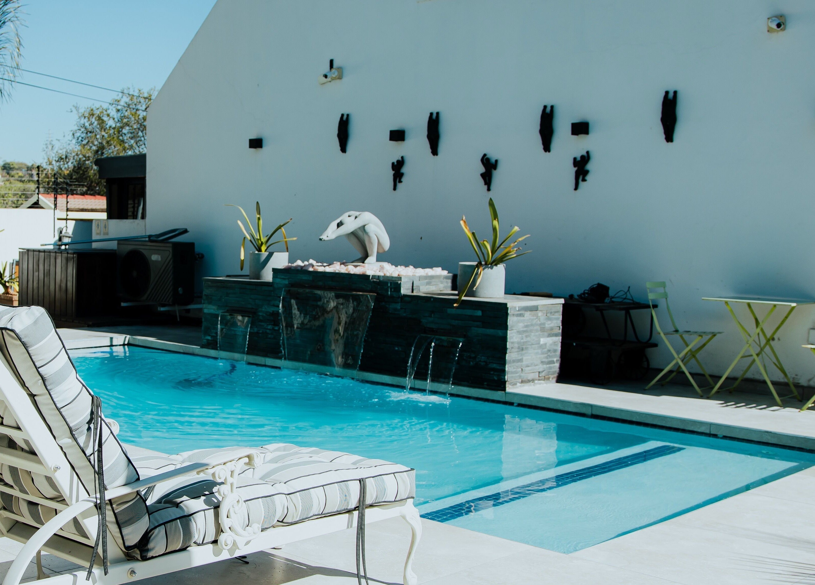 Relax by the pool at Thari Spa, Centurion, Gauteng, ZA, featuring elegant loungers and soothing water features.