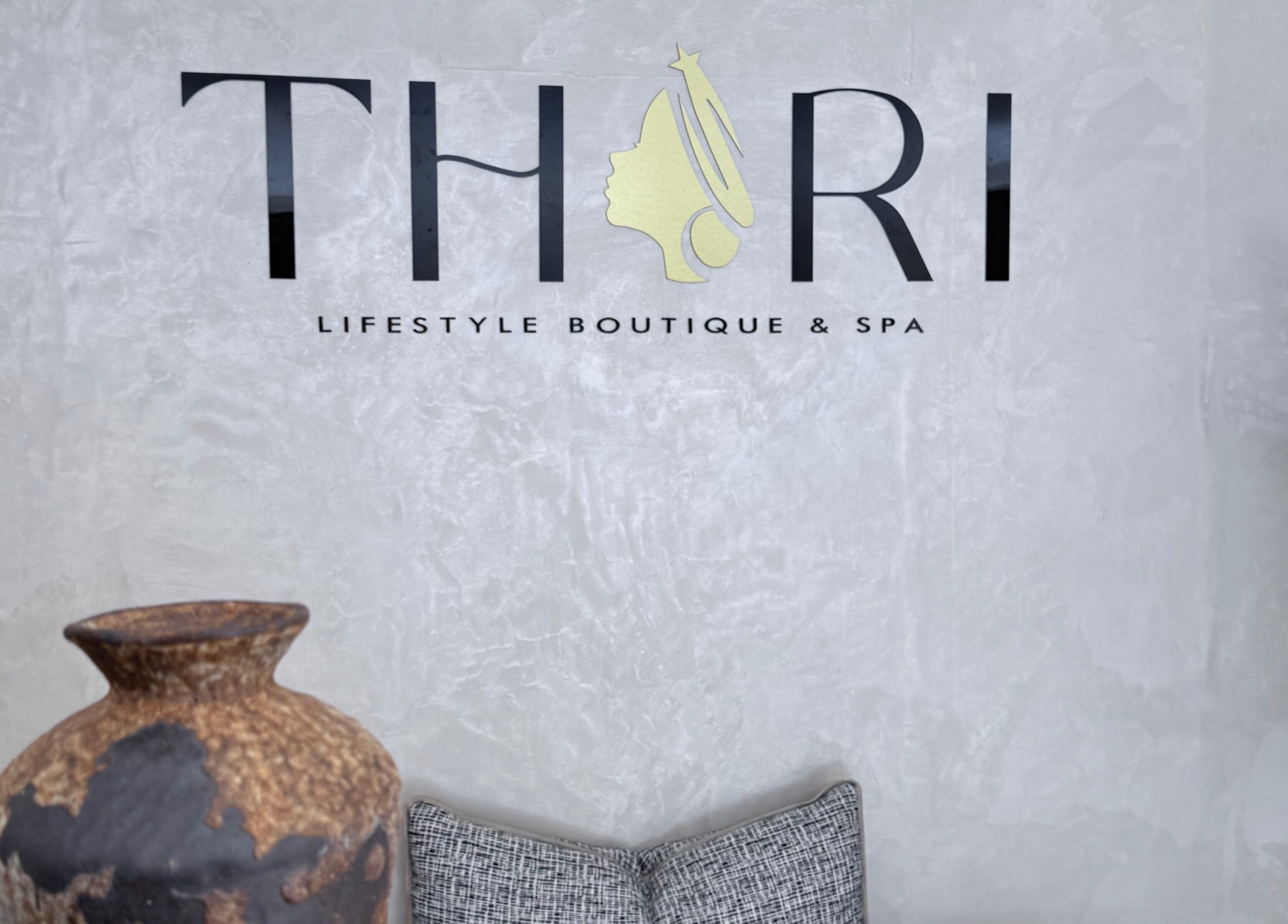 Thari Spa logo on textured wall with pottery in Centurion, Gauteng, ZA.