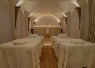 Luxurious spa room at Another Mars, Dubai, Dubai, AE with four massage beds under a vaulted ceiling.