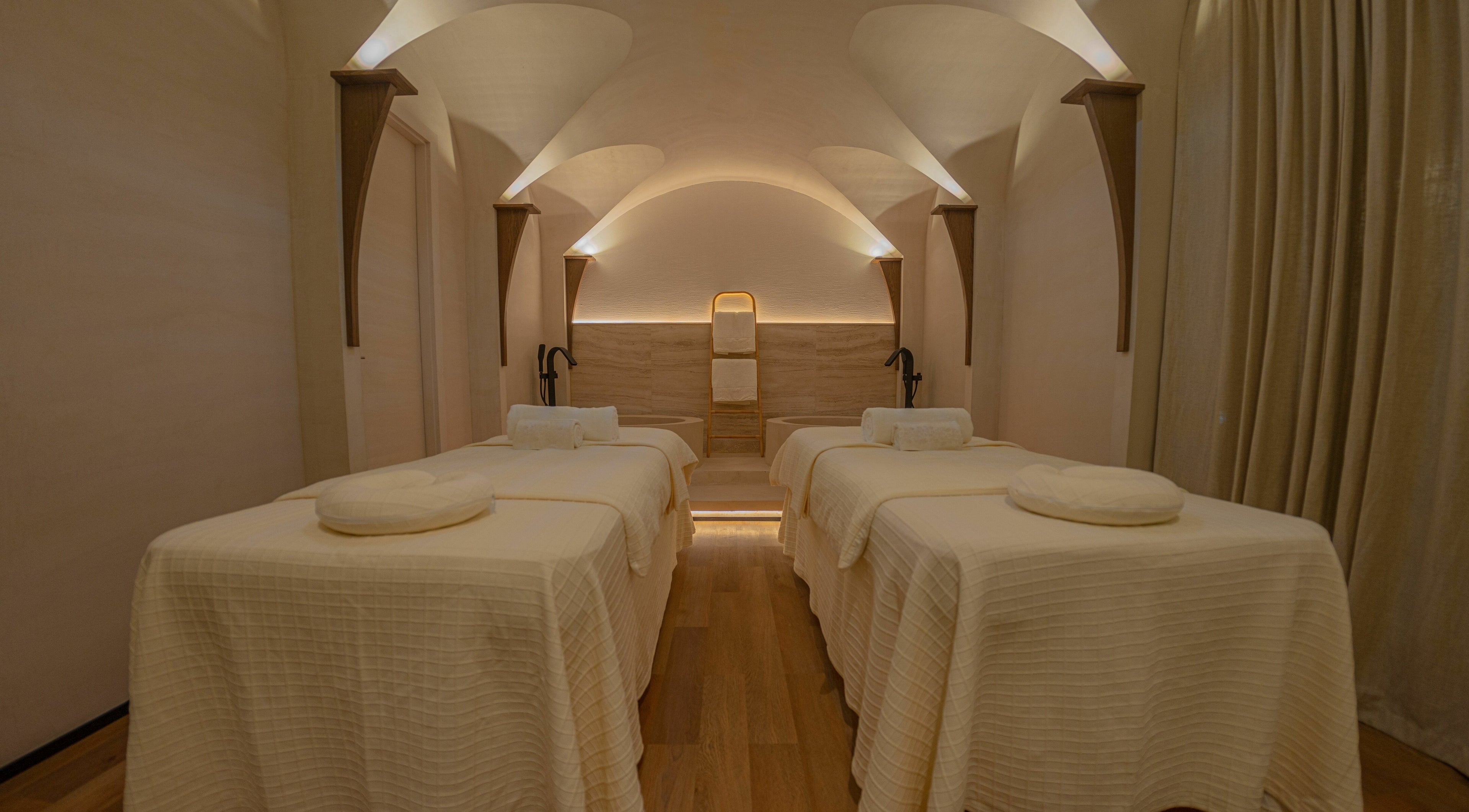 Luxurious spa room at Another Mars, Dubai, Dubai, AE with four massage beds under a vaulted ceiling.