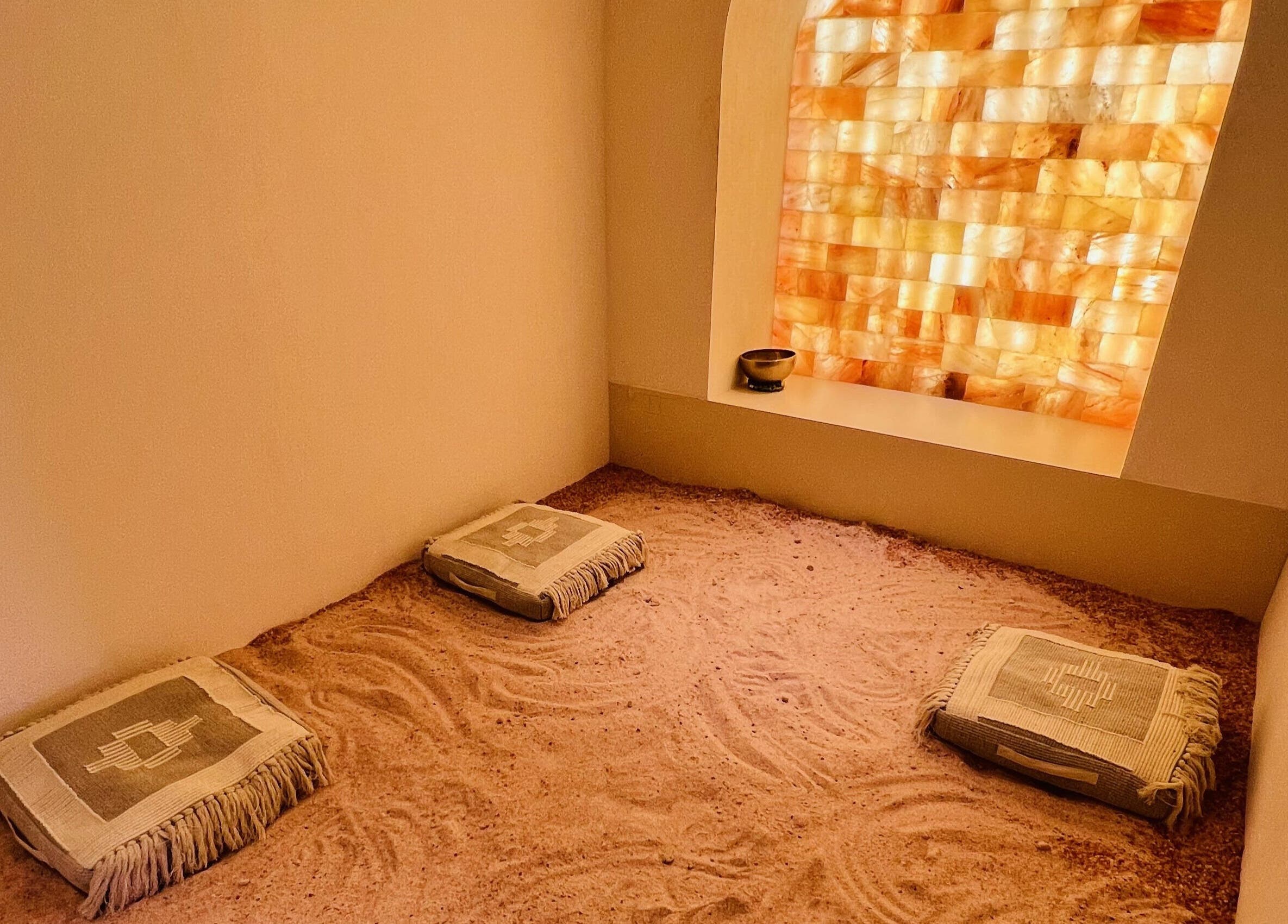Tranquil salt therapy room at Another Mars, Dubai, Dubai, AE with cushions and a glowing salt wall.