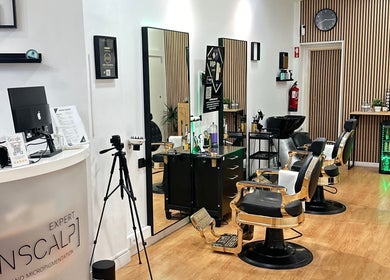 Interior elegante do Menscalp em Parede, Lisboa, PT, com cadeiras de barbearia e decoração moderna.