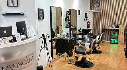 Interior elegante do Menscalp em Parede, Lisboa, PT, com cadeiras de barbearia e decoração moderna.