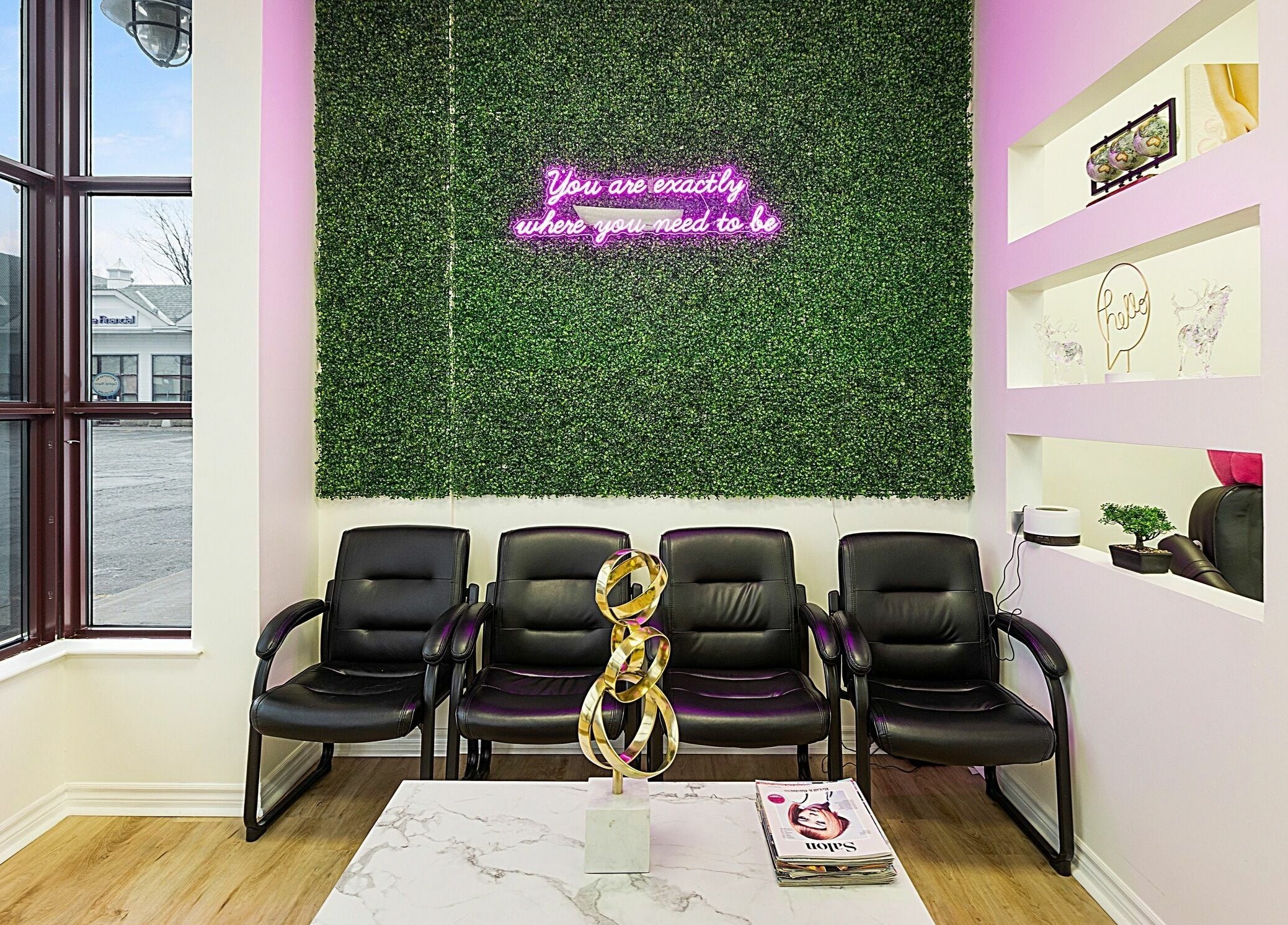 Chic waiting area at Divine Day Spa, Ottawa, Ontario, CA with plush chairs and neon sign.
