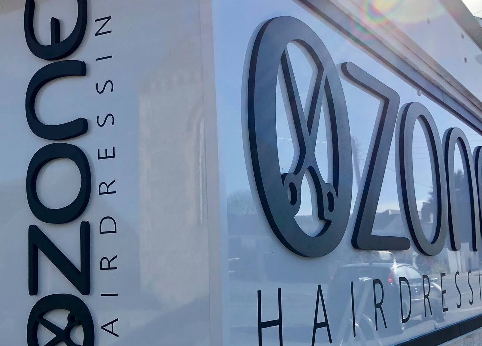 Exterior signage of Ozone hairdressing salon in Truro, England, GB, showcasing modern design.