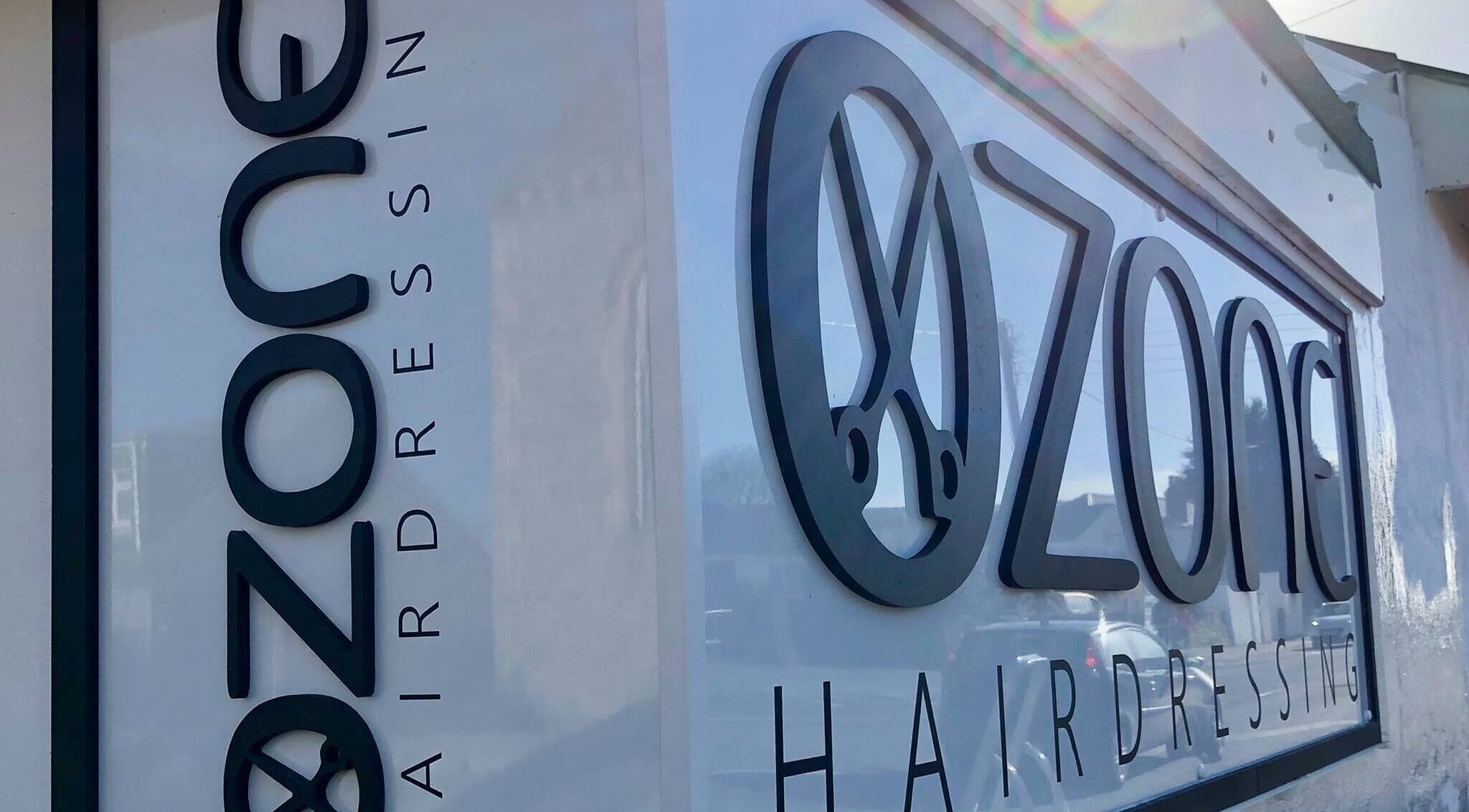 Exterior signage of Ozone hairdressing salon in Truro, England, GB, showcasing modern design.