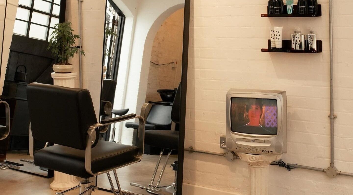 Chic hair salon corner at Studio Studios, London, England, GB showcasing modern chairs and retro TV.