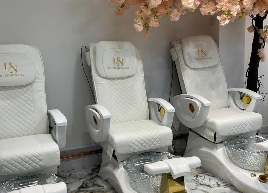 Elegant spa chairs at House of Nailz™ in Dunstable, England, GB, under cherry blossom decor.