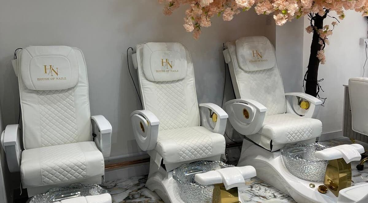 Elegant spa chairs at House of Nailz™ in Dunstable, England, GB, under cherry blossom decor.