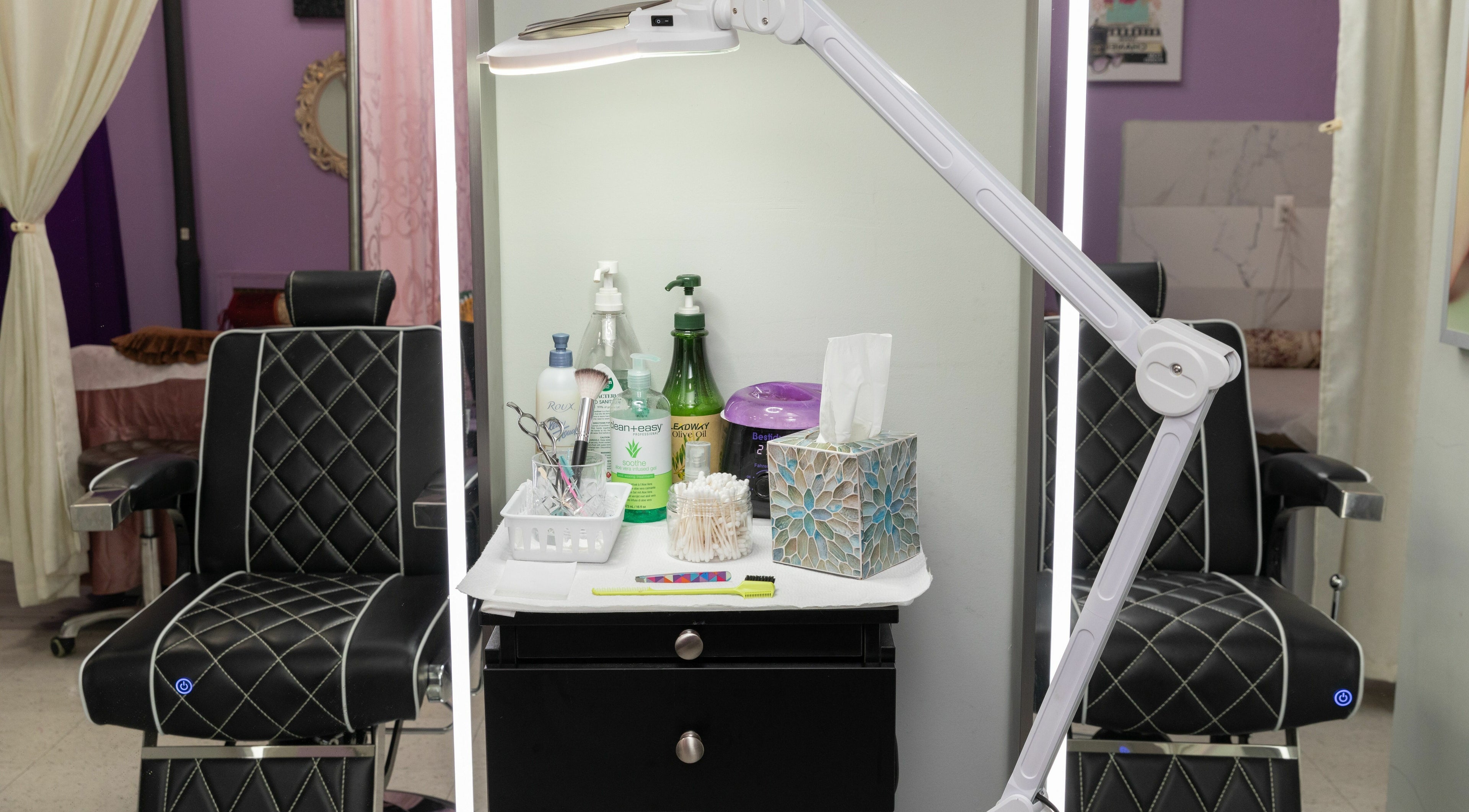 A beauty station at Wonder Lash Studio Queens, Long Island City, US with reclining chairs and skincare products.