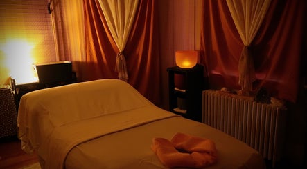 Cozy massage room at Boon Massage & Healing, Arlington, Massachusetts, US with warm lighting and elegant curtains.