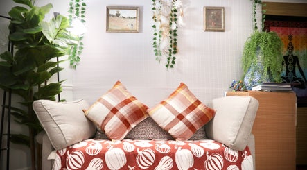 Relaxing seating area at Boon Massage & Healing, Arlington, Massachusetts, US with cushions and greenery.