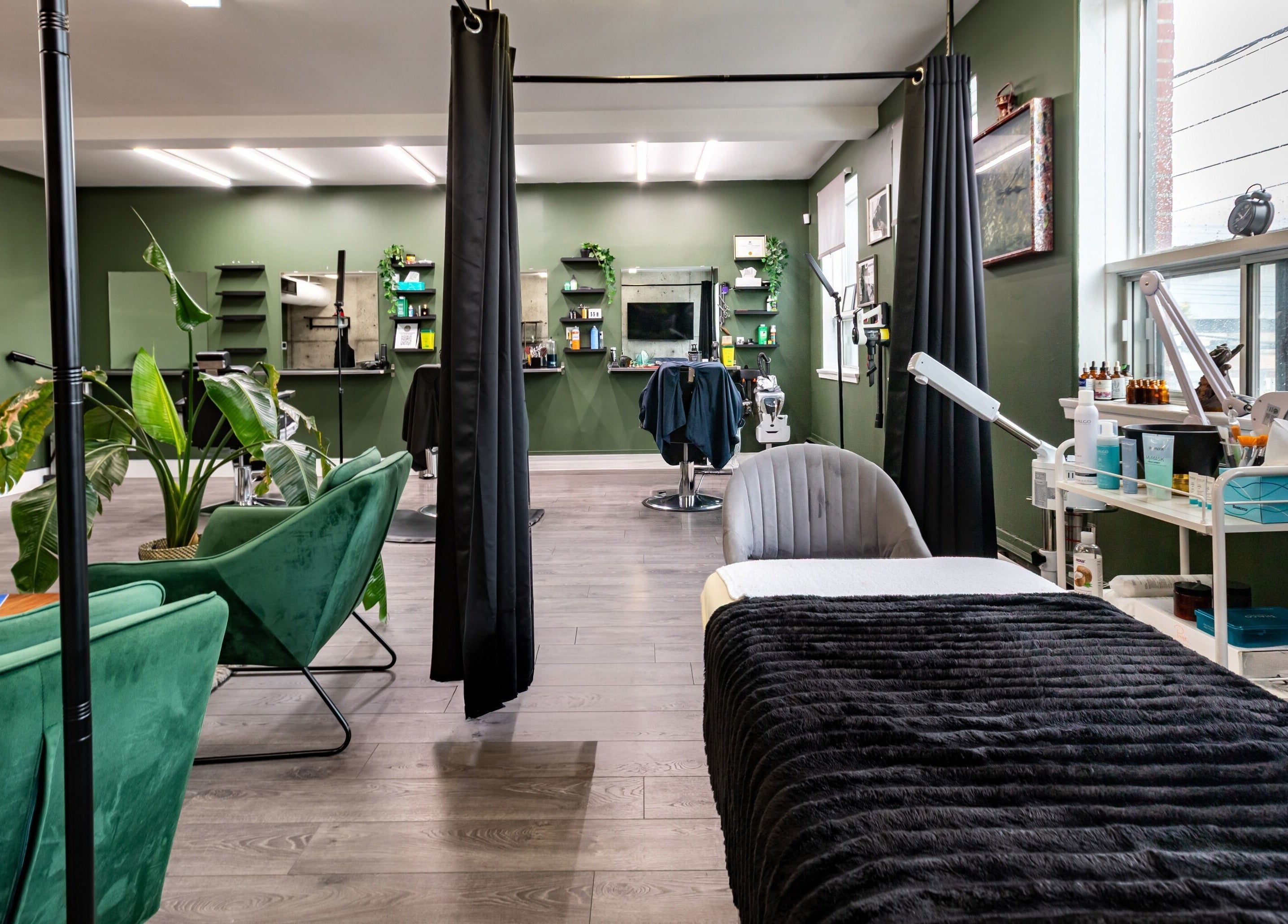 Inviting spa interior at Quantum Field Studio in Montréal, Québec, CA featuring green seating and dark decor.