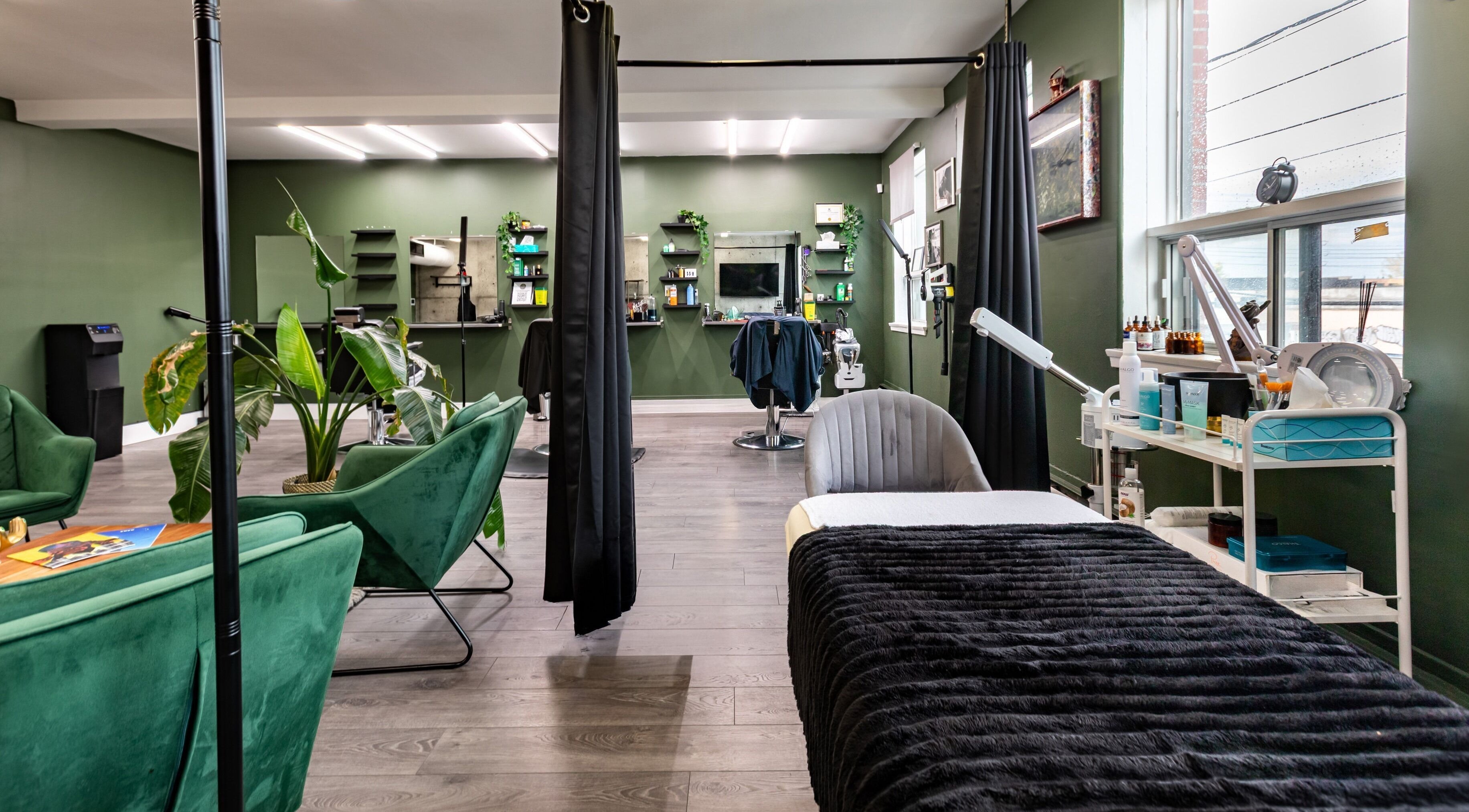 Inviting spa interior at Quantum Field Studio in Montréal, Québec, CA featuring green seating and dark decor.