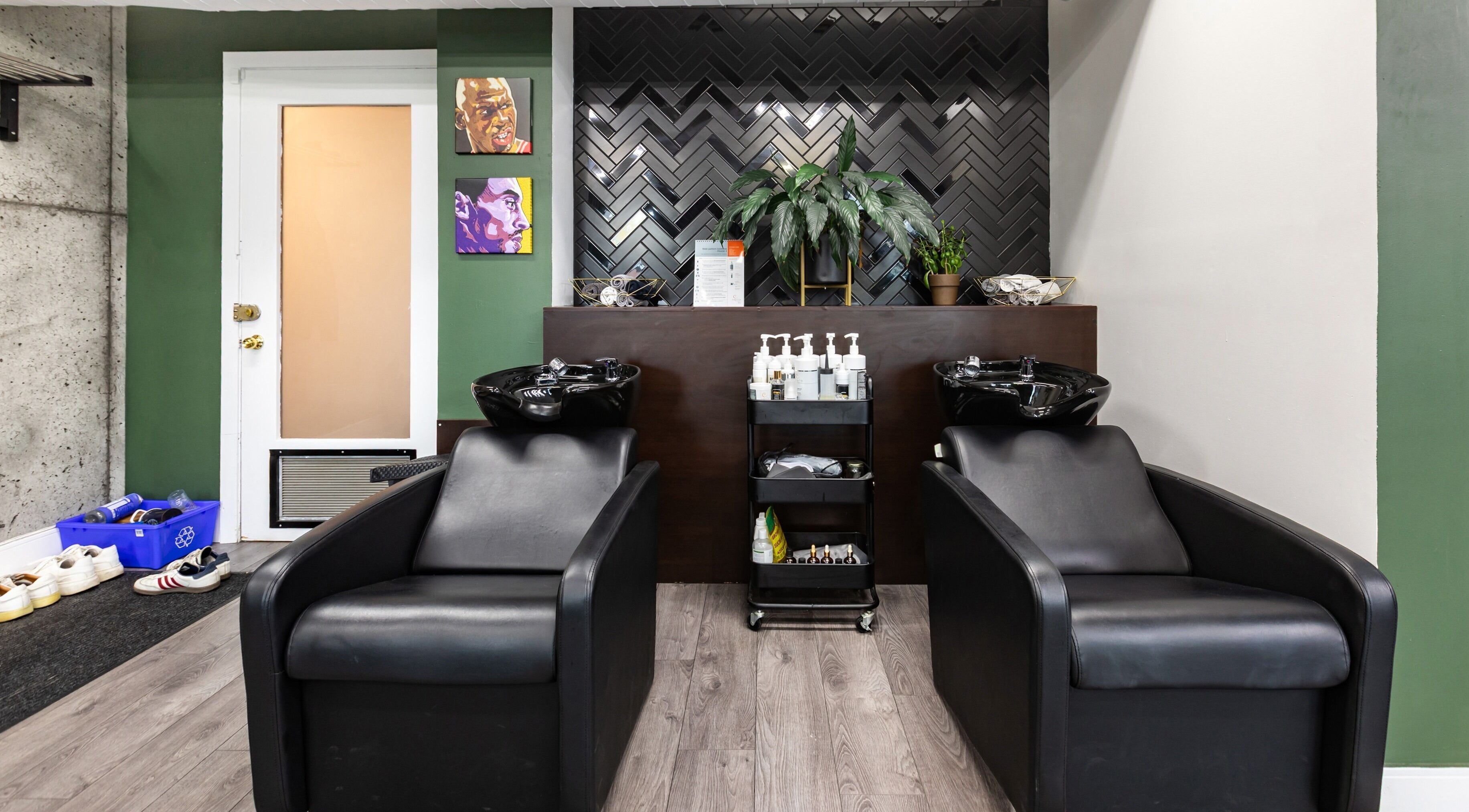 Chic hair wash station at Quantum Field Studio in Montréal, Québec, CA with sleek black chairs and stylish decor.