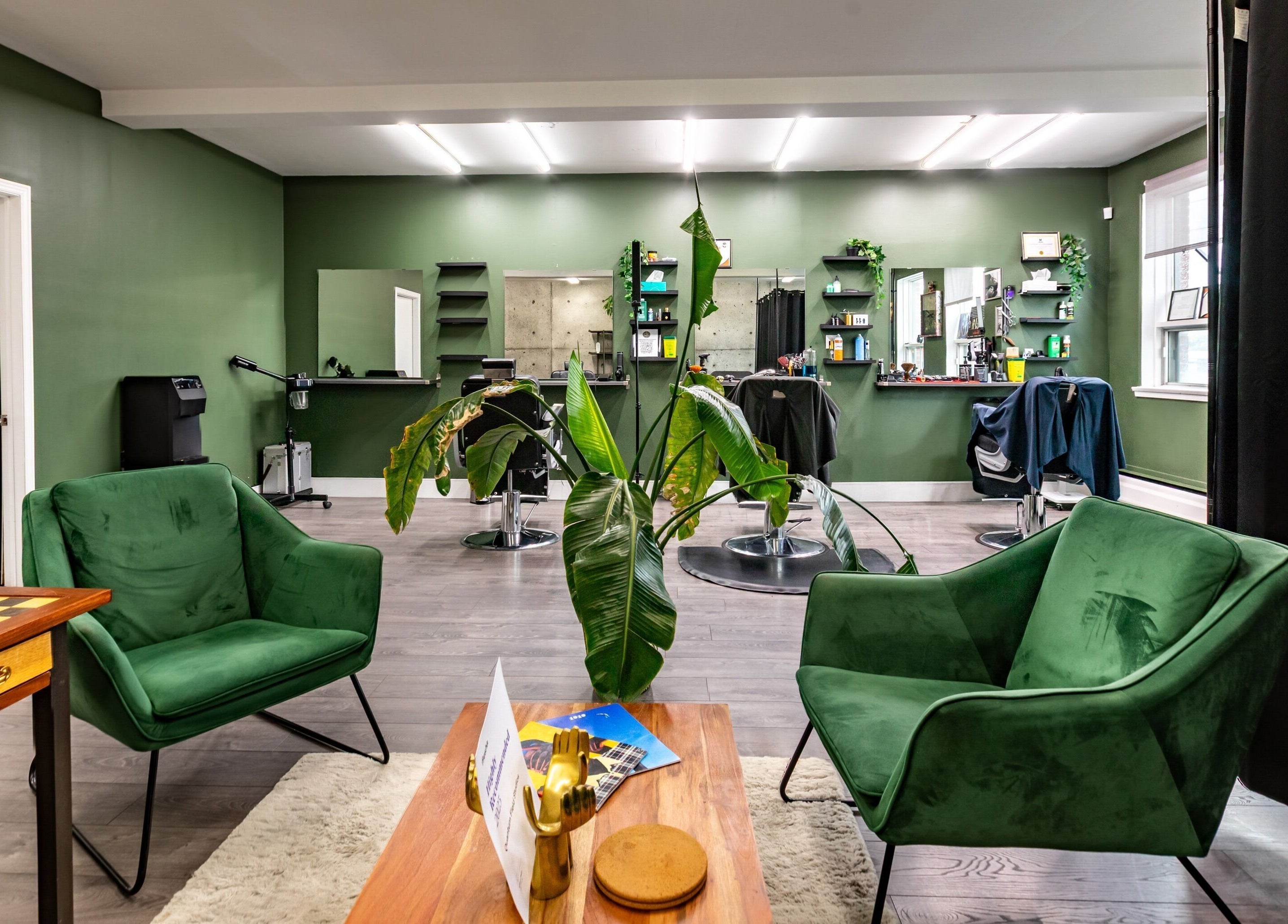 Stylish green lounge at Quantum Field Studio, Montréal, Québec, CA with plants and sleek furniture.