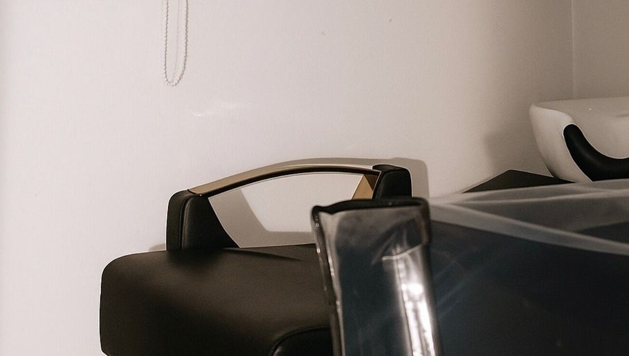 Área de lavado en Rootsxyeliann, Caguas, Caguas, PR. Sillón negro y lavabo moderno en ambiente sereno.