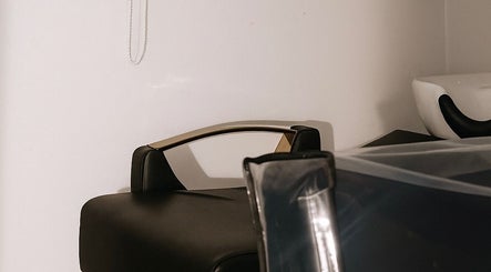 Área de lavado en Rootsxyeliann, Caguas, Caguas, PR. Sillón negro y lavabo moderno en ambiente sereno.