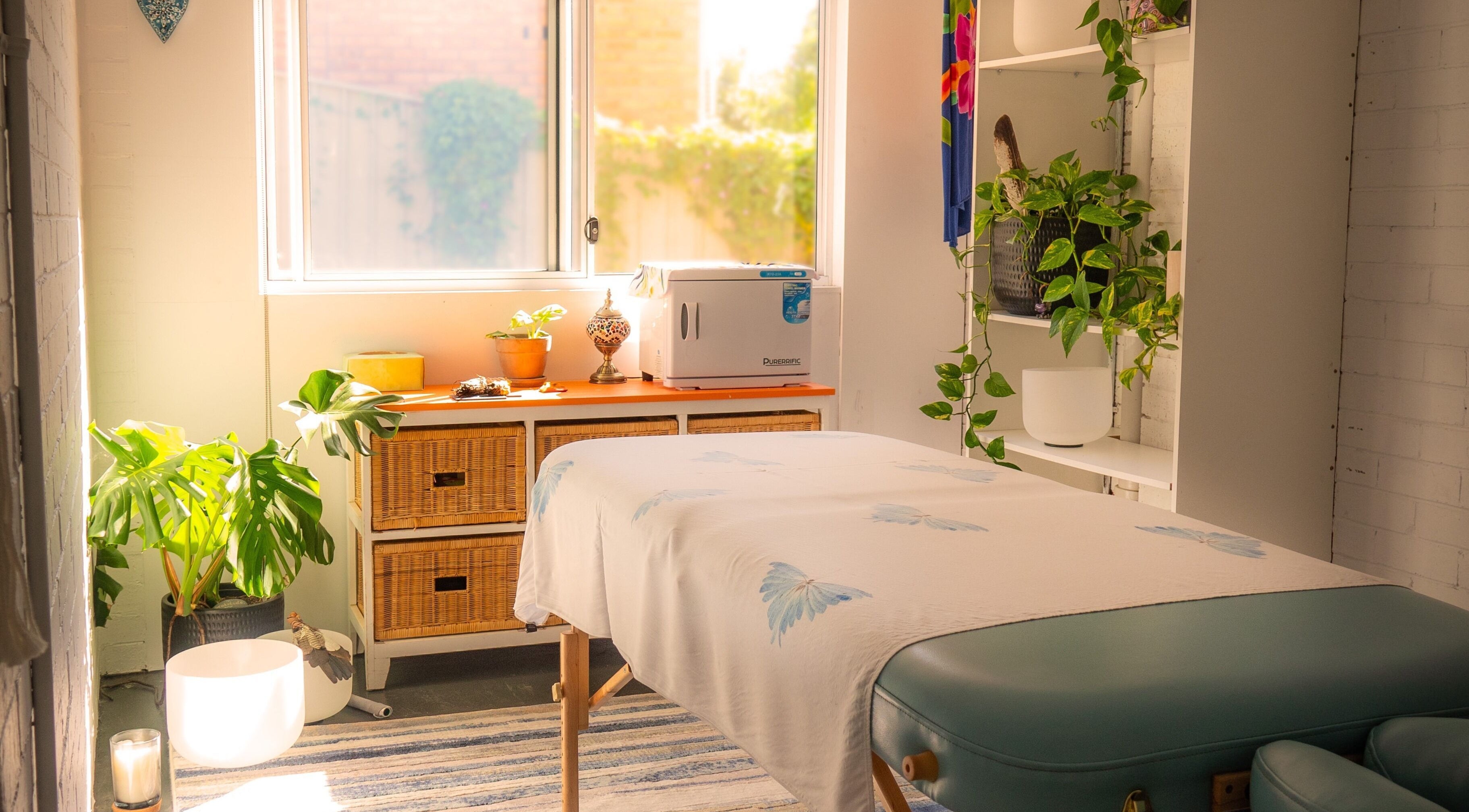 Relaxing massage room at Lomi Lomi Massage Therapy Charlestown, New South Wales, AU with natural light and plants.