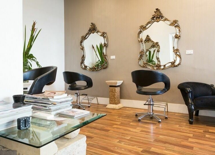 Elegant seating area at Absolute Hair Design in Edgecliff, New South Wales, AU with chic decor and mirrors.