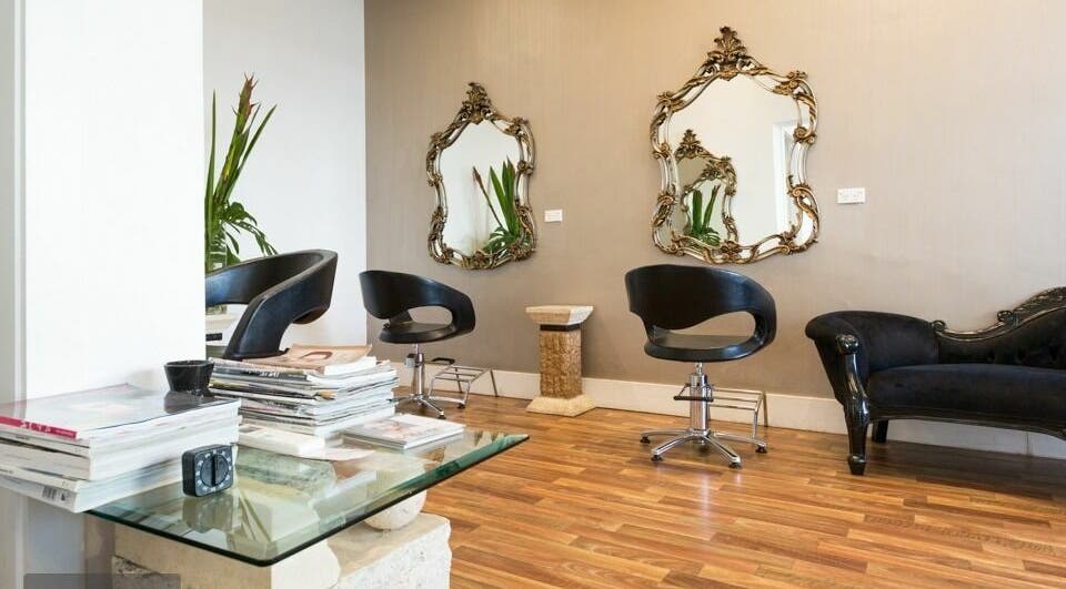 Elegant seating area at Absolute Hair Design in Edgecliff, New South Wales, AU with chic decor and mirrors.