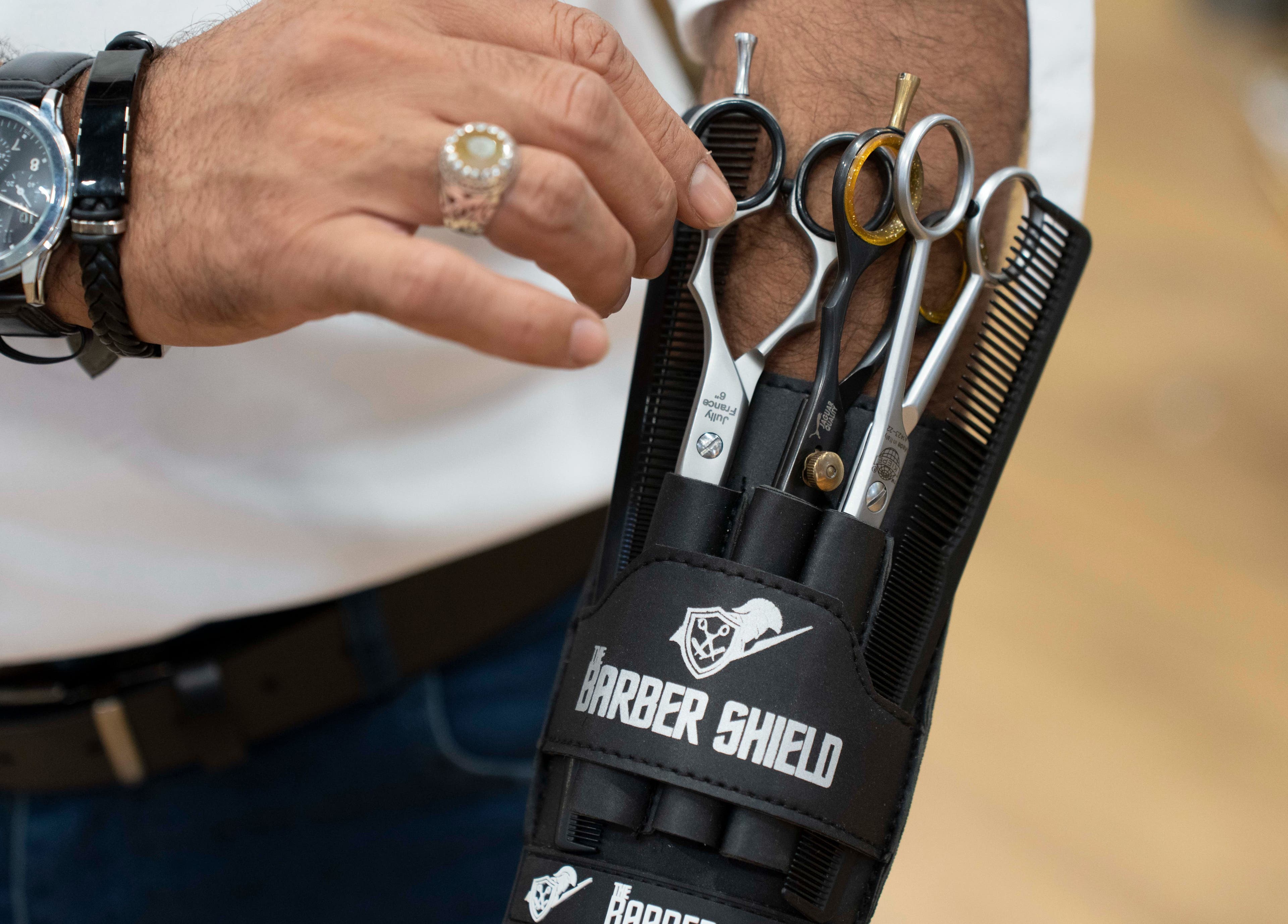 Hand selecting scissors at Secret Care Barber Shop, Sharjah, Sharjah, AE, featuring Barber Shield pouch.