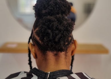 Stylish afro updo at Enhle Afro Salon in Mthatha, Eastern Cape, ZA, showcasing intricate braiding.