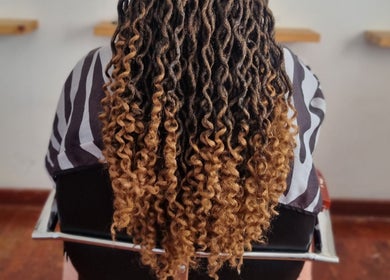 Stylish curly hairstyle at Enhle Afro Salon in Mthatha, Eastern Cape, ZA, showcasing distinct texture and color.