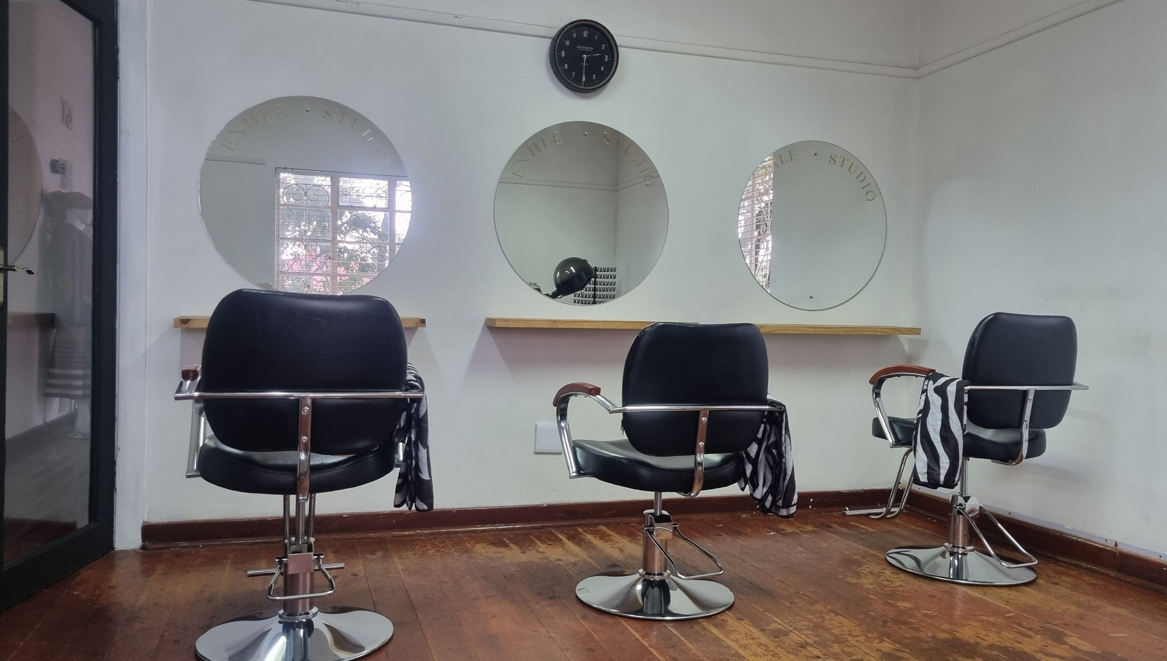 Stylish salon chairs at Enhle Afro Salon in Mthatha, Eastern Cape, ZA. Modern mirrors and sleek design.