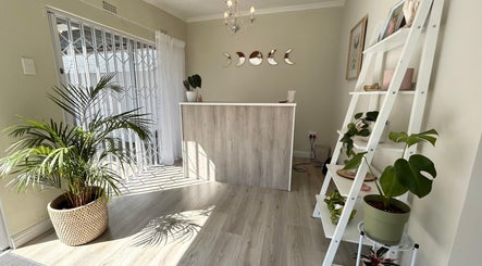 Bright reception area at New Moon Brow Artistry, Randburg, Gauteng, ZA, featuring elegant decor and potted plants.