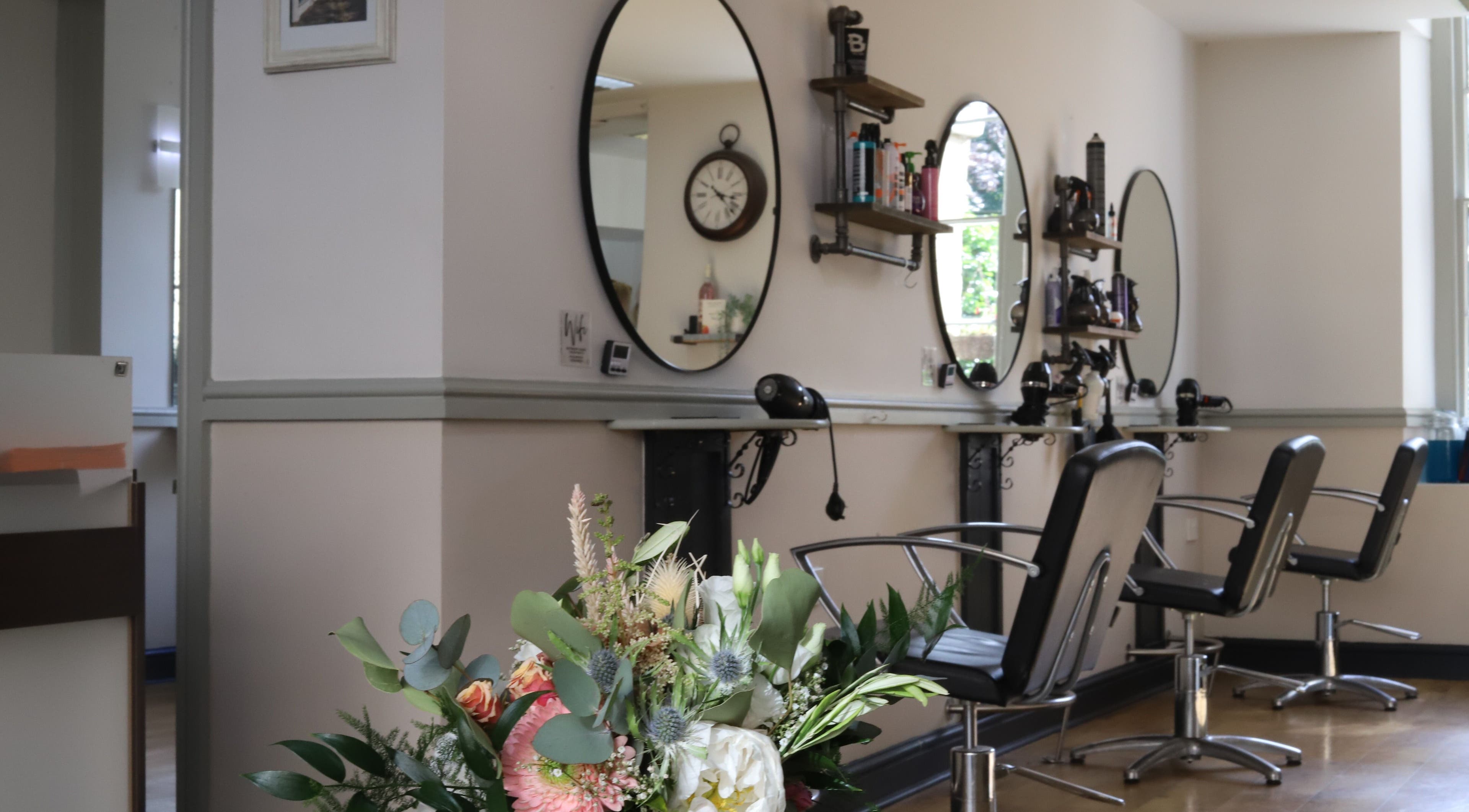 Elegant interior of Strawberry Fields Hair Design in Corsham, England, featuring stylish salon chairs and mirrors.
