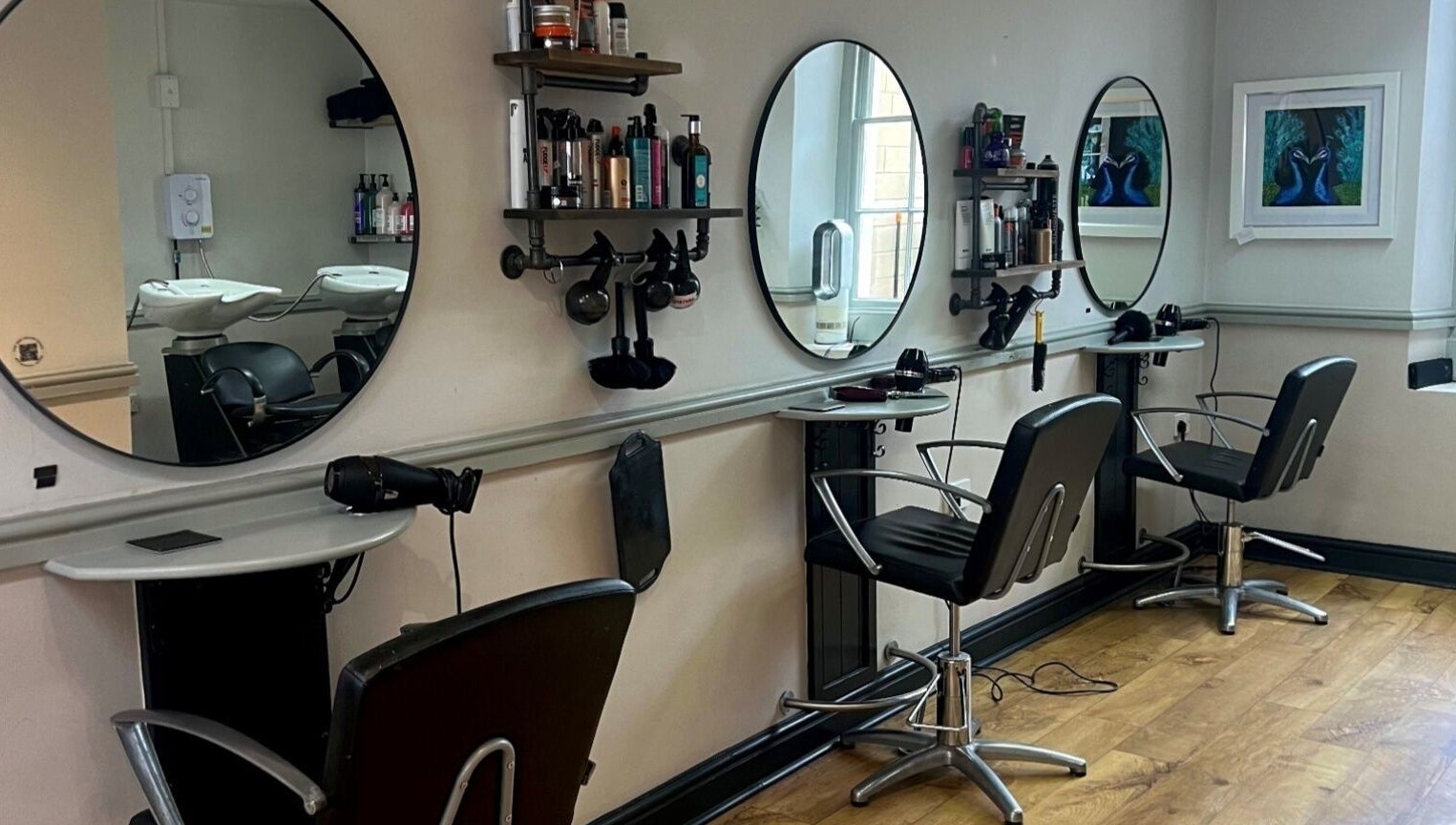 Modern salon interior at Strawberry Fields Hair Design, Corsham, England, GB, showcasing sleek styling stations.