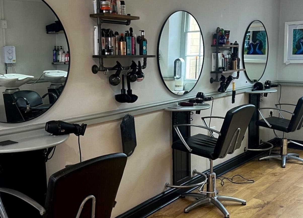 Modern salon interior at Strawberry Fields Hair Design, Corsham, England, GB, showcasing sleek styling stations.