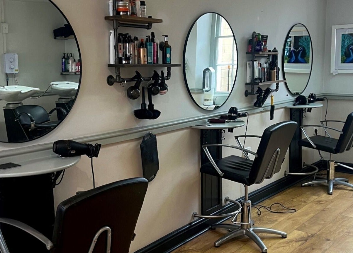 Modern salon interior at Strawberry Fields Hair Design, Corsham, England, GB, showcasing sleek styling stations.