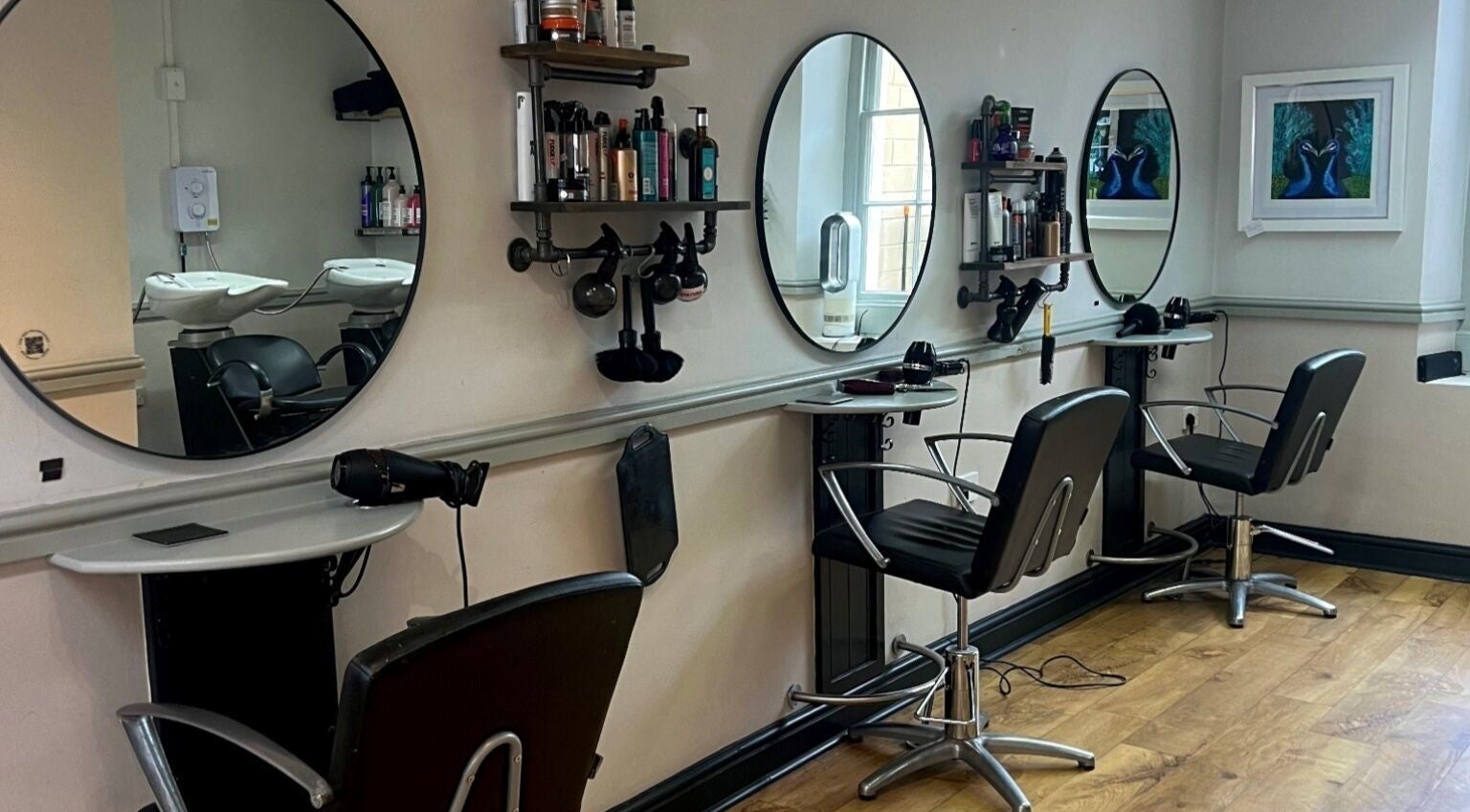 Modern salon interior at Strawberry Fields Hair Design, Corsham, England, GB, showcasing sleek styling stations.