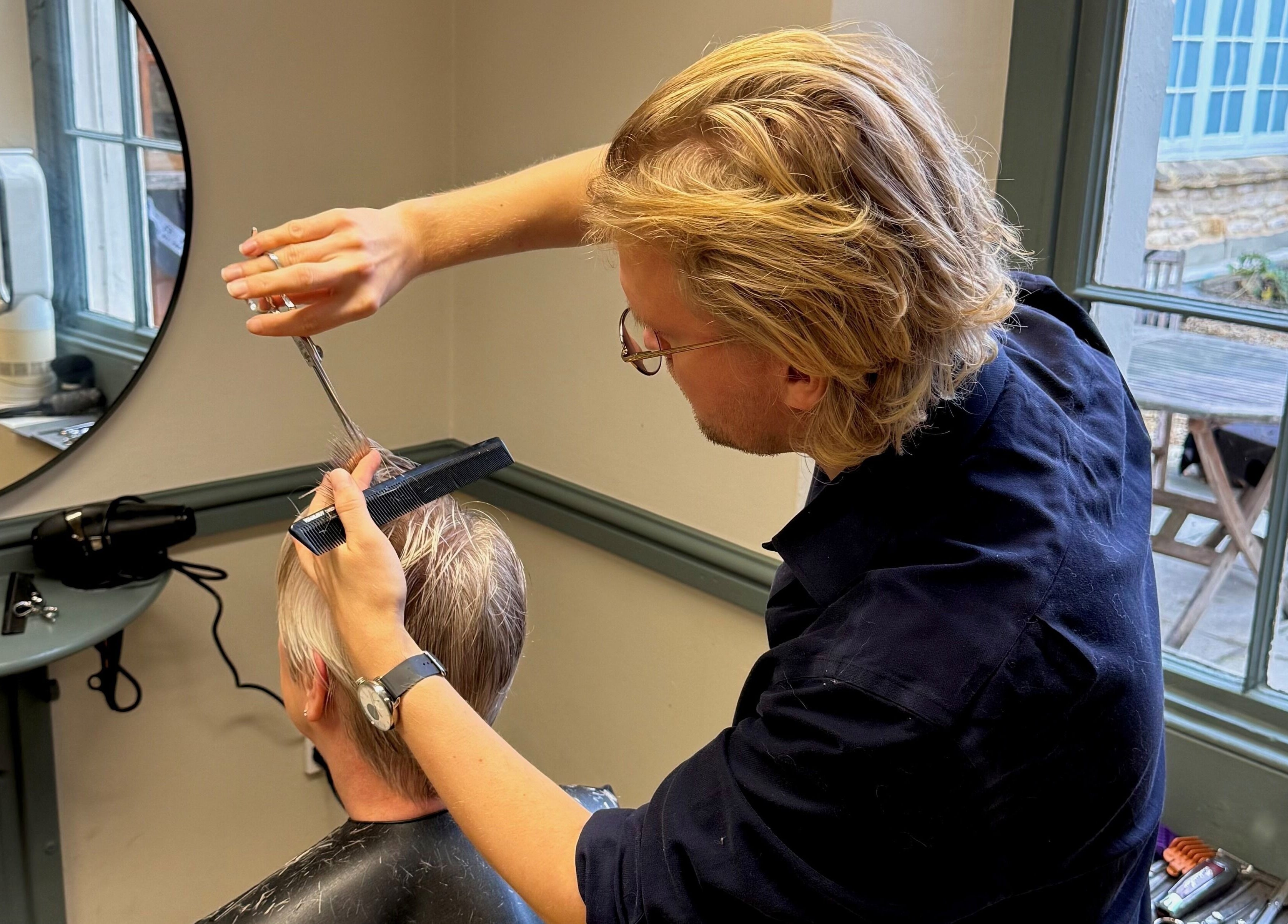 Stylist shaping hair at Strawberry Fields Hair Design, Corsham, England, GB.