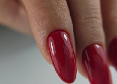 Close-up of red manicure by Nail Design by Maja, Olney, England, GB, showcasing glossy finish.