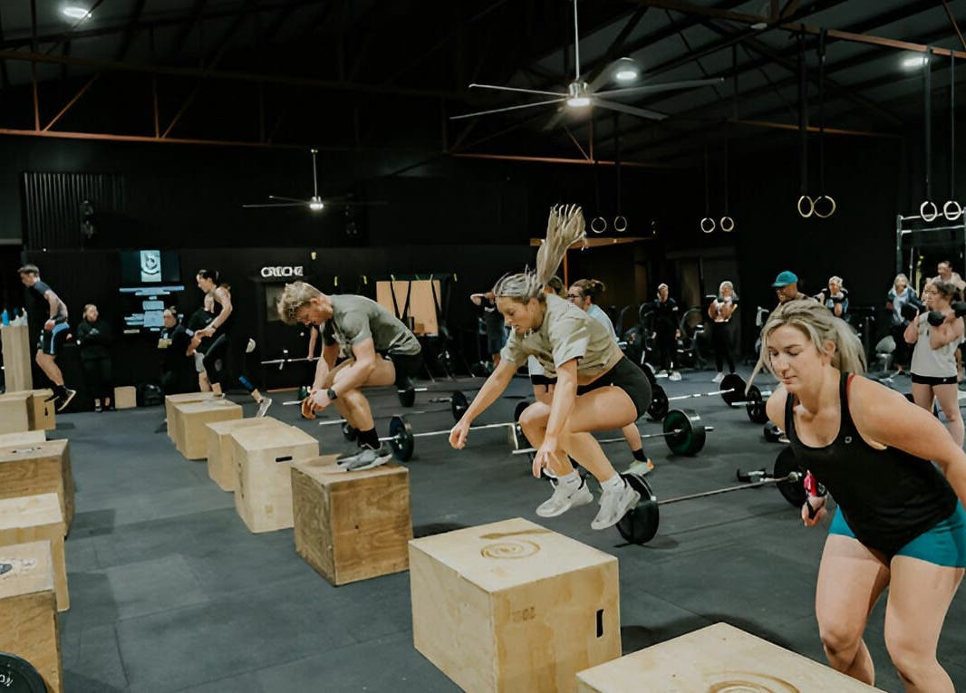 Energetic fitness class at Complete Body, Toowoomba City, Queensland, AU with participants jumping onto boxes.