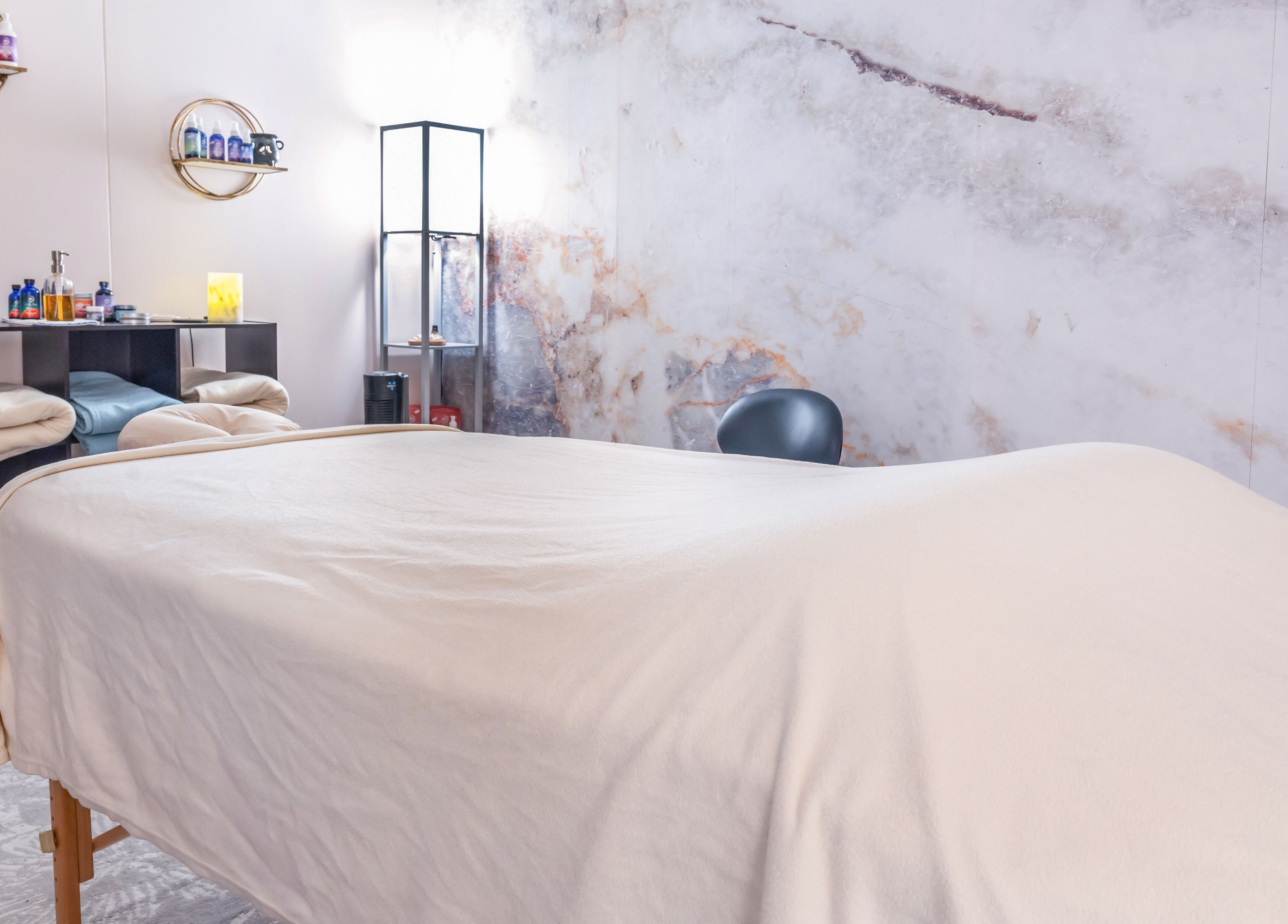 Calming spa room at Open Your Heart, Saline, Michigan, US with massage table and essential oils.